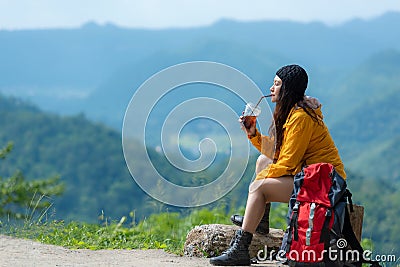 Hiker asian woman sitting and drinking coffee for relax and rest on mountain. Female adventure backpack and trips camping on hike Stock Photo