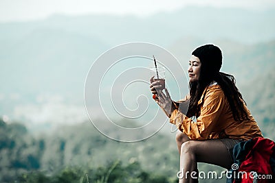 Hiker asian woman sitting and drinking coffee for relax and rest on mountain. Female adventure backpack and trips camping on hike Stock Photo