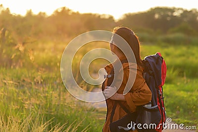 Hiker asian women walking in national park with backpack. Woman tourist going camping in meadow forest, Stock Photo