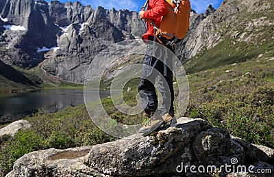 Hiker with backpack hiking on high altitude mountain Stock Photo