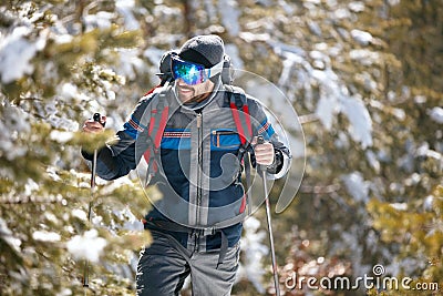 Hiker with backpack trekking in mountains. Cold weather, snow on Stock Photo