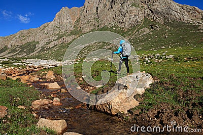 Hiker with backpack walking on high altitude mountain Stock Photo