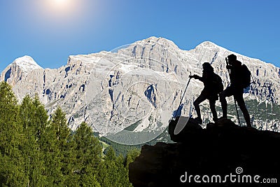 Hiker with backpacks reaches the summit of mountain peak. Success, freedom and happiness, Achievement in mountains. Active sport c Stock Photo