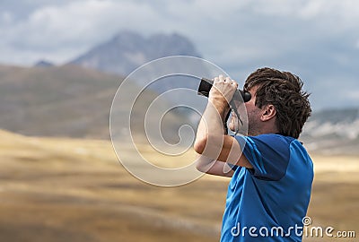 Man scanning the sky with binoculars Stock Photo