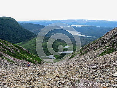 A hiker climbing a massive scree slope on the way to the summit of Gros Morne Mountain, in Gros Morne National Park, Newfoundland Stock Photo