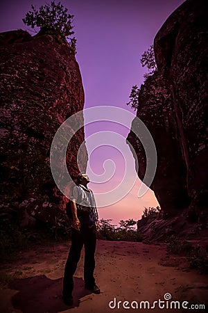 Hiker enjoying the view, against silhouette of rock mountains at sunset, Three whale rock mountain Stock Photo
