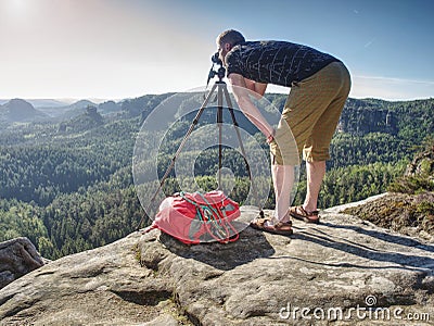 Hiker framing picture with the face on the camera on cliff Stock Photo