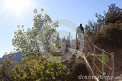 Hiker going up the stairs in the mountain Stock Photo