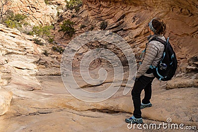 Hiker Looking Down Steep Rock Wash On The Trail To Druid Arch Stock Photo