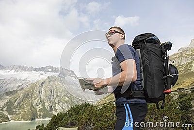 Hiker looks for the right way with the help of a map Stock Photo