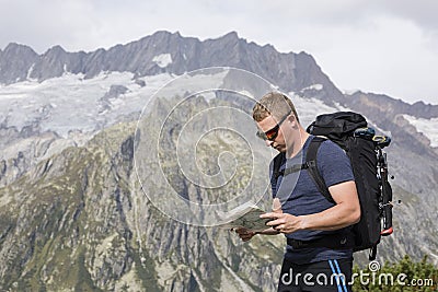 Hiker looks for the right way with the help of a map Stock Photo