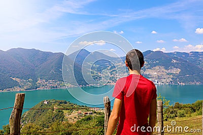 Hiker man standing admiring a mountaintop view looking out over distant ranges of mountains and valleys in a healthy Stock Photo