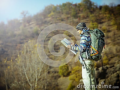 Hiker with map exploring wilderness on trekking adventure Stock Photo