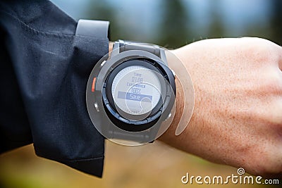 Hiker on mountain trail checking compass, wearable technology Stock Photo