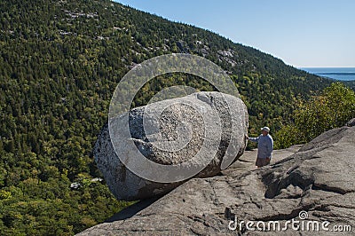 Hiker Next To The Bubble Rock. The Bubble Rock Is A Glacial Erratic Located Near The Summit Of South Bubble In Acadia National Editorial Stock Photo