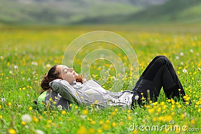Hiker resting on the grass in the mountain Stock Photo