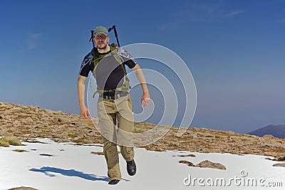 Hiker in a snowfield in the mountains Stock Photo