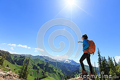 Hiker stand at cliff edge on mountain top Stock Photo