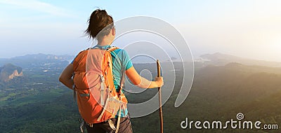 Hiker stand at cliff edge on mountain top Stock Photo