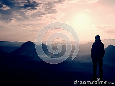 Hiker stand on the sharp corner of sandstone rock in rock empires park and watching over the misty and foggy morning valley to Sun Stock Photo