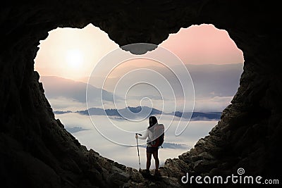 Hiker with stick pole standing inside cave Stock Photo