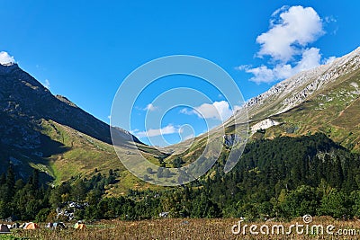 Hiker camp in autumn meadow in front of a mountain pass Stock Photo