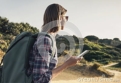 Hiker traveler woman on a hiking trail using smartphone, travel and active lifestyle concept Stock Photo