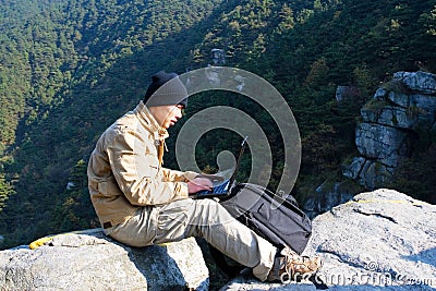 Hiker using a laptop outdoors Stock Photo