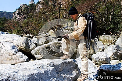 Hiker using a laptop outdoors Stock Photo