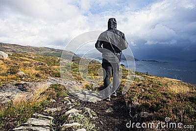 Hiker walking in the mountains on a rainy day, goal succes and freedom. Travling Norway landscape Editorial Stock Photo