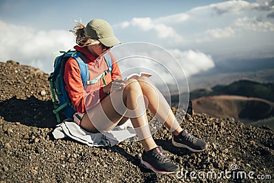 Hiker woman reading book on sloops of Mt Etna Stock Photo