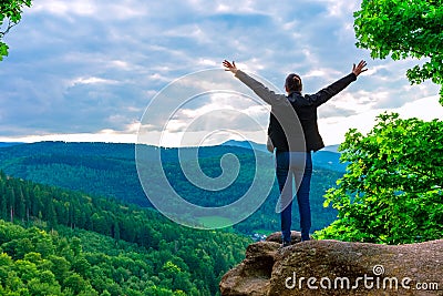 Hiker woman standing with hands up achieving the top Stock Photo