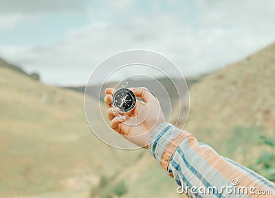 Woman searching direction with a compass in mountains, pov. Stock Photo