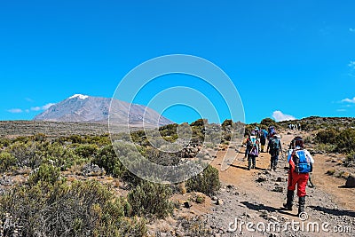 Hikers against a mountain background, Mount Kilimanjaro Editorial Stock Photo