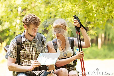 Hikers backpackers couple reading map on trip. Stock Photo