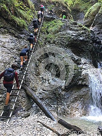 Hikers climb stairs up to the gorge near waterfall Editorial Stock Photo