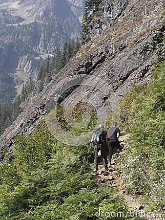 Hikers climbing steep mountain trail Editorial Stock Photo