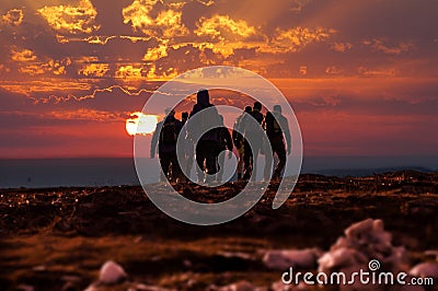 Hikers reach mountain top at sunset Stock Photo