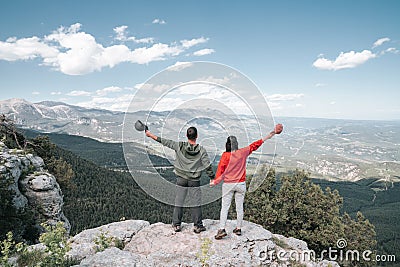 Hikers relaxing on top of a mountain and enjoying the view of valley Stock Photo