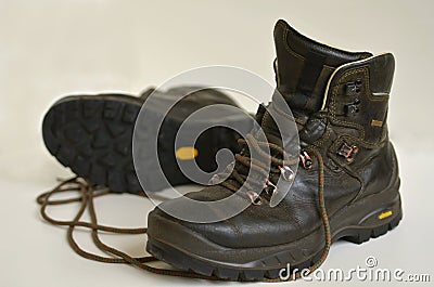 Old weathered natural leather hiking boots isolated on white background. Stock Photo