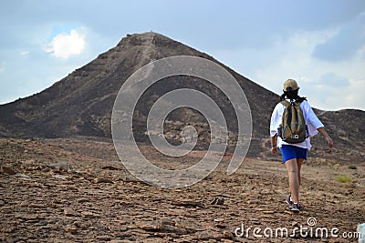 Hiking towards mountain at bottom of Makhtesh Ramon Crater, Mitzpe Ramon, Negev desert, Israel Editorial Stock Photo
