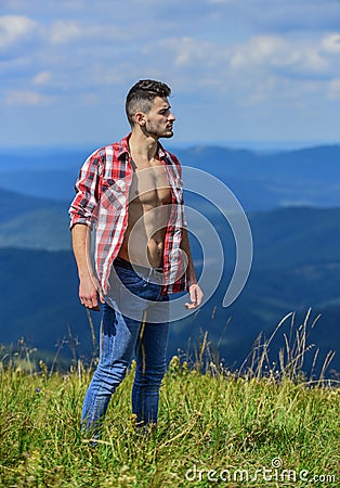 Hiking concept. Strong hiker muscular torso. Athlete muscular guy relax mountains. Power of nature. Man unbuttoned shirt Stock Photo