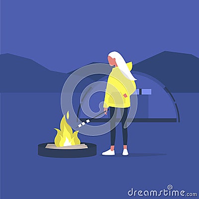Hiking in forest, young female tourist roasting marshmallows on a campfire Stock Photo