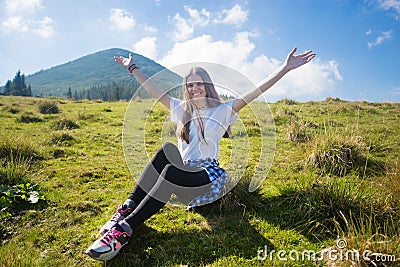 Hiking girl on top of hill with hands up enjoy mountain view. Stock Photo