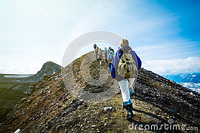 Hiking on Kamchatka: group of hiker with backpack goes in mountain on Volcano Goreliy on a sunny day. Kamchatka Peninsula, Russia Editorial Stock Photo