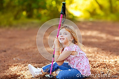 Hiking kid girl tired sitting in autumn forest Stock Photo