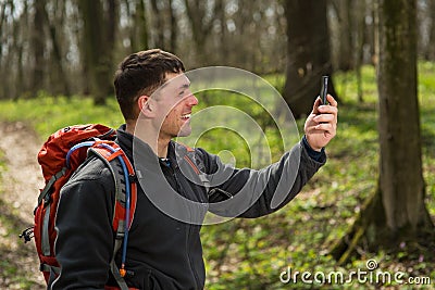 Hiking man take selfie during his walk through the forest Stock Photo