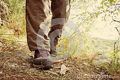 Hiking shoes with red laces and legs wearing long brown trousers Stock Photo