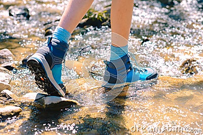 Hiking shoes - sole of trekking boots and legs in a mountain stream Stock Photo