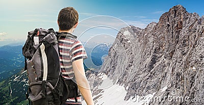 Hiking tourist with backpack from behind. Alps in background. Stock Photo